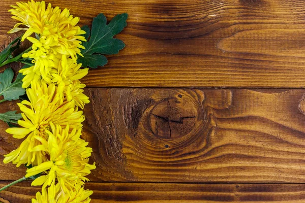 Ahşap arka planda sarı kasımpatılar. Üst görünüm, alanı kopyala