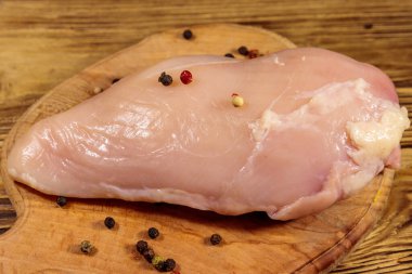 Ahşap masa üzerinde kesme tahtası üzerinde Çiğ tavuk göğsü