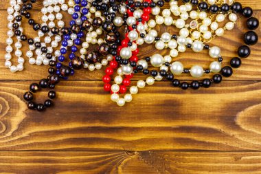 Ahşap arka planda farklı boncuk kolyeler