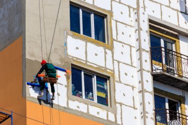 Kremenchug, Ukrayna - 3 Nisan 2020: Yüksek katlı binanın yapay köpük yalıtımı. İp girişi çalışıyor. Endüstriyel yükseklik kavramı