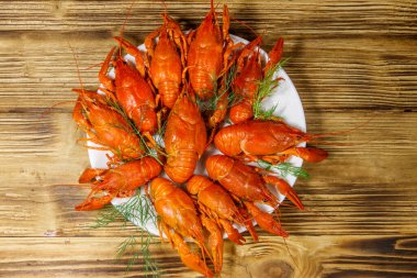 Ahşap masada kaynamış kerevit tabağı. Üst görünüm