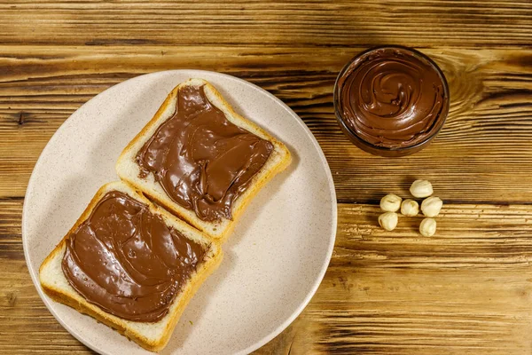 Duas Fatias Pão Com Deliciosa Avelã Chocolate Espalhadas Mesa Madeira — Fotografia de Stock