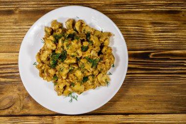 Ahşap masada ekşi kremalı mantar yahnisi. Üst görünüm