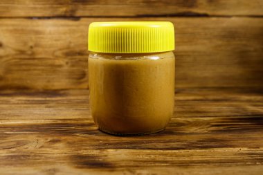 Tahta bir masada fıstık ezmesi kavanozu