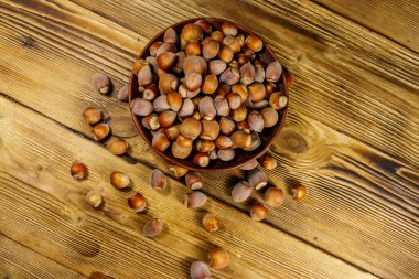 Tahta bir masada seramik tabakta fındıklar. Üst görünüm