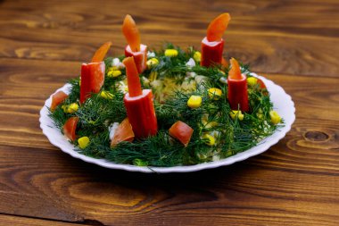Tahta masada salata Noel çelengi.