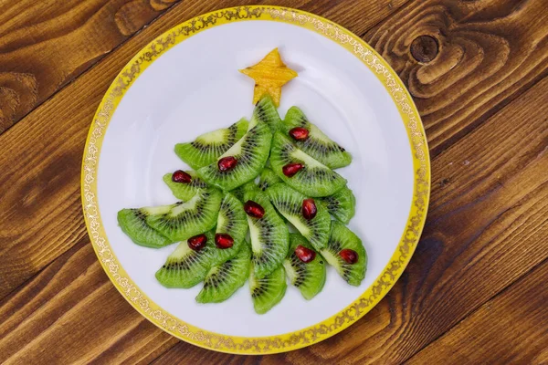 Christmas Tree Made Kiwi Slices Pomegranate Wooden Table Top View — Stock Photo, Image
