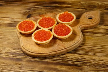 Tahta bir masada kırmızı havyarlı turta.