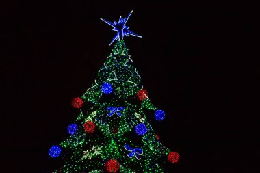 Geceleyin çok renkli ışıklarla süslenmiş Noel ağacı