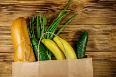 Tahta masa üzerinde farklı yiyecekler olan kağıt torba. Üst Manzara. Market alışverişi kavramı