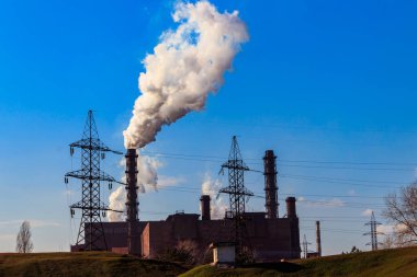 Dumanlı boruları olan eski bir fabrika manzarası. Hava kirliliği, çevresel hasar