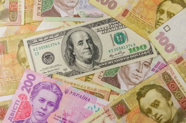 Farklı Ukrayna Hryvnia banknotlarının arka planında 100 dolarlık banknot