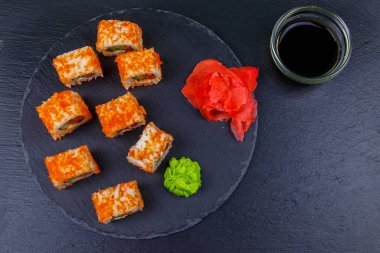 Suşi Philadelphia 'yı siyah bir levhada yuvarlıyor. Üst görünüm