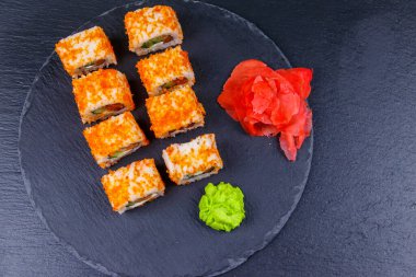 Suşi Philadelphia 'yı siyah bir levhada yuvarlıyor. Üst görünüm