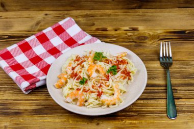 Karidesli makarna, domates sosu ve ahşap masada maydanoz.