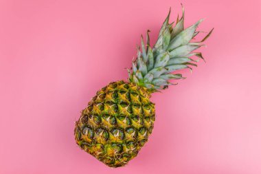 Pembe arka planda koca bir ananas. Üst görünüm