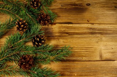 Noel kompozisyonu köknar ağacı dalları ve tahta arka planda koniler. Üst görünüm, alanı kopyala