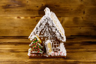 Noel zencefilli kurabiye evi ahşap bir masanın üstünde.