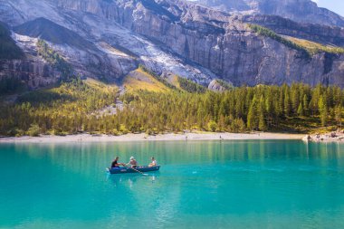 Kandersteg, İsviçre - 4 Eylül 2022: İsviçre 'nin Bernese Oberland kentindeki Kandersteg yakınlarındaki Oeschinen Gölü' nde (Oeschinensee) kürek çeken insanlar