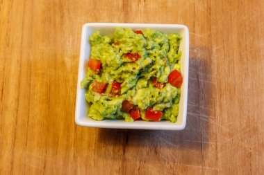 Tahta bir masada bir kase guacamole.