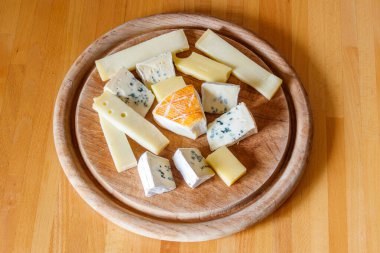 Tahta masada farklı peynirler bulunan peynir tabağı.