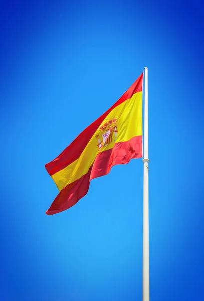 Spanish flag waving against clear blue sky