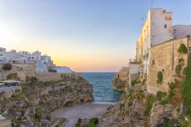 Polignano a Mare içinde günbatımı: kayaların arasındaki güzel Plajı