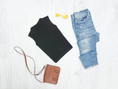 Siyah T-shirt, kot pantolon, çanta ve güneş gözlüğü sökük. Moda kavramı