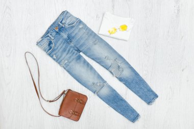 Düzensiz mavi kot pantolon, çanta ve güneş gözlüğü. Moda kavramı