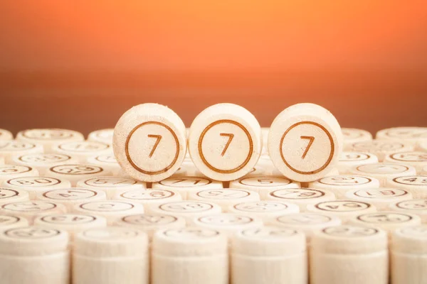 Lucky number 777 on the wooden keg lotto. Black background. Close up