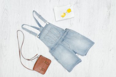 Mavi kot romper, el çantası ve güneş gözlüğü. Moda kavramı