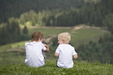 İki erkek bir tepe üzerinde oturmak ve eğlenin. Arkadan görünüm