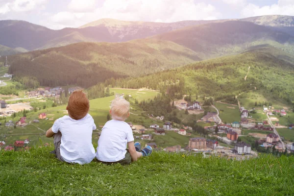 Два Мальчика Сидят Холме Смотрят Горы Вид Сзади — стоковое фото