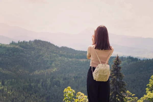 Girl Backpack Smartphone Photographs Mountains Forest Back View Sunny Summer — Stock Photo, Image