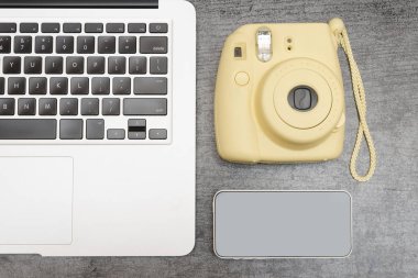Laptop klavye, sarı bir kamera ve bir akıllı telefon parçası. Üstten görünüm