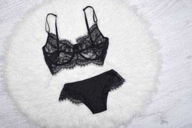 Siyah dantel iç çamaşırı beyaz kürk üzerinde. Moda kavramı