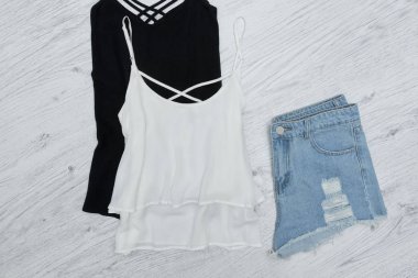 Siyah ve beyaz kolsuz bluz ve yırtık kot şort. Moda kavramı