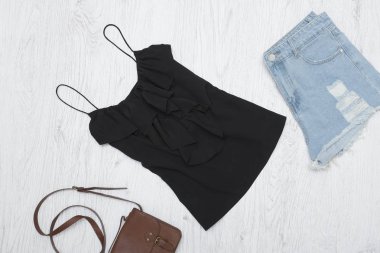 Siyah tişört, çanta ve yırtık kot şort. Moda kavramı