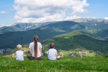 Aile tatili. Anne ve iki oğlu dağın manzarayı. Arkadan görünüm. Güneşli yaz gün