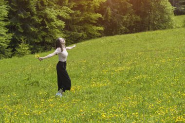 Gülümseyen genç kadın ile bir buket çiçek sahaya dönüyor. Yaz günü