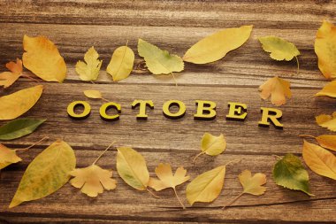 Ahşap arka plan üzerinde yazıt Ekim, çerçeve sarı yaprakları