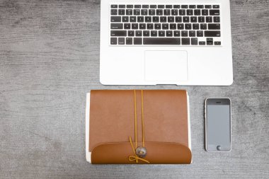 Laptop klavye, kahverengi Not defteri ve bir akıllı telefon parçası. Uzay kopyalayın. Üstten görünüm