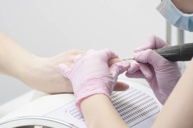 Kız eldiven tırnaklar manikür için freze kesici ile işler. Yakın çekim