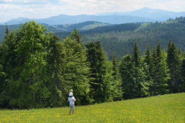 Onun omuzlarında küçük oğlu olan babası. Yaz güneşli gün. Arkadan görünüm
