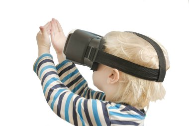 Sanal gerçeklik gözlüklü küçük sarışın çocuk. Ellerine bakar