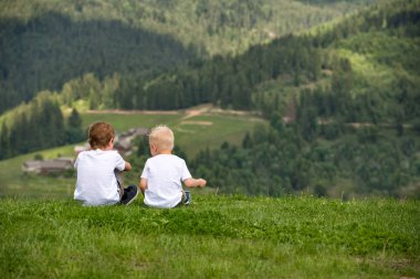 İki erkek tepe ve neşeyle konuşurken otur. Arkadan görünüm