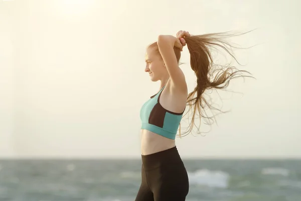 Дівчина Спортивному Одязі Пляжі Коригує Волосся Ранкове Світло — стокове фото