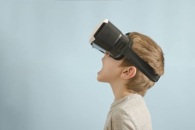 Sanal gerçeklik gözlüklü çocuk. Açık ağız. Mavi arka plan