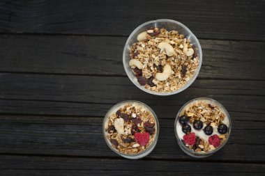 Granola ile kaşu bir fincan yoğurt ile. Koyu ahşap arka plan