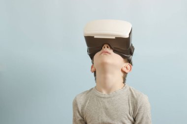 Sanal gerçeklik gözlüklü çocuk. Arama yapar. Mavi arka plan